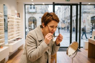 Femme essayant des lunettes dans une opticien en centre-ville de Brest